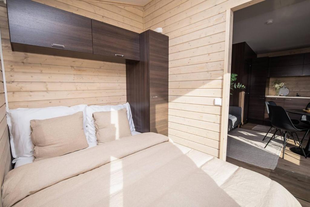 a bedroom with a bed with a wooden wall at Compact and Cozy Cabin in Yllas for Work and Play in Ylläsjärvi