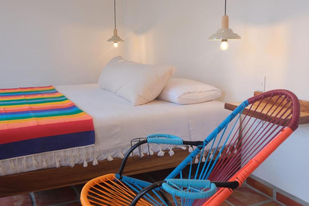 a chair in a room with a bed and a bed at Sayulita beach-side studio 2 by CasasTropical in Sayulita