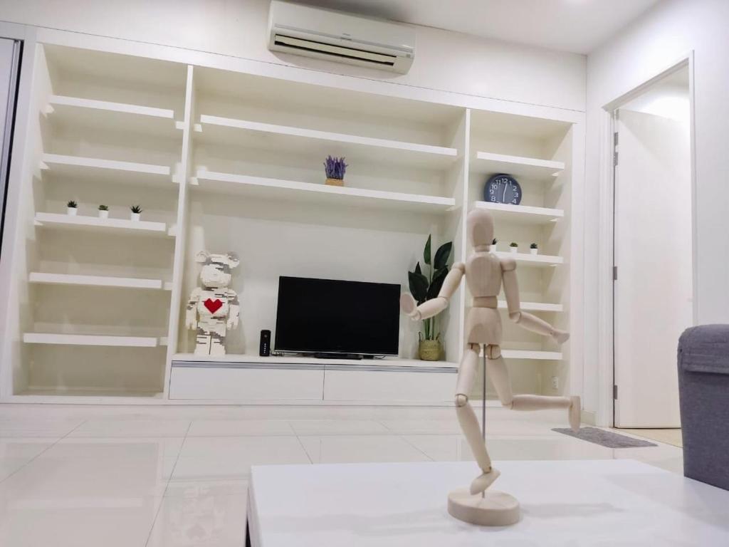 a mannequin standing in a living room with a tv at Camellia Serviced Suites in Kuala Lumpur