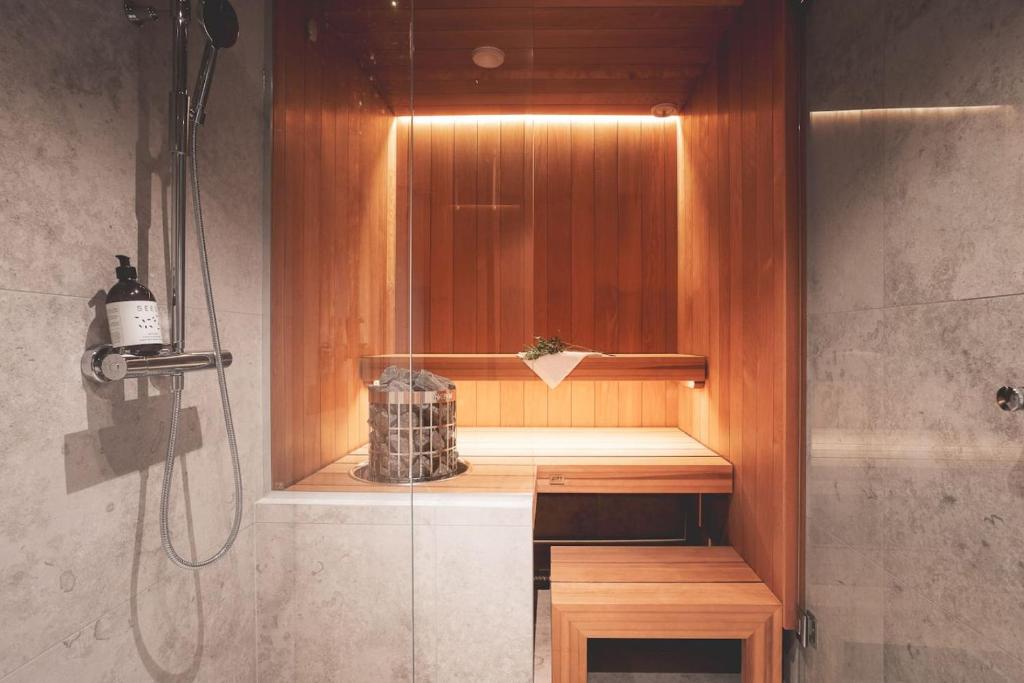a bathroom with a shower with a wooden shelf and a shower at Stay North - Joiku - Kajo in Äkäslompolo