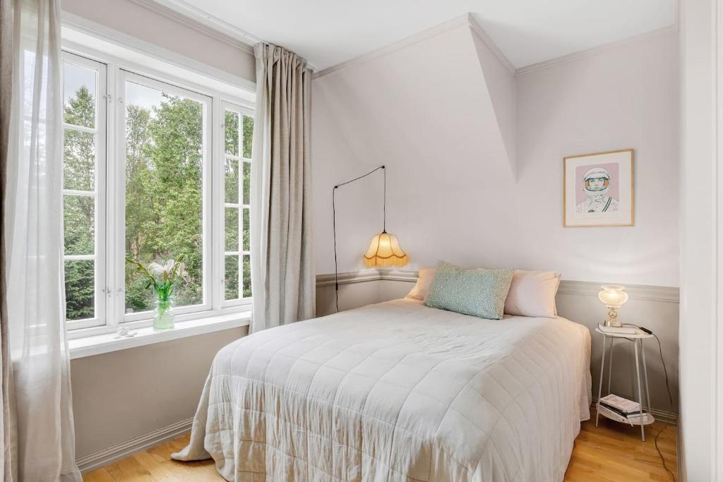 a white bedroom with a bed and a window at Arctic hilltop lodge - Room 3 in Guleng