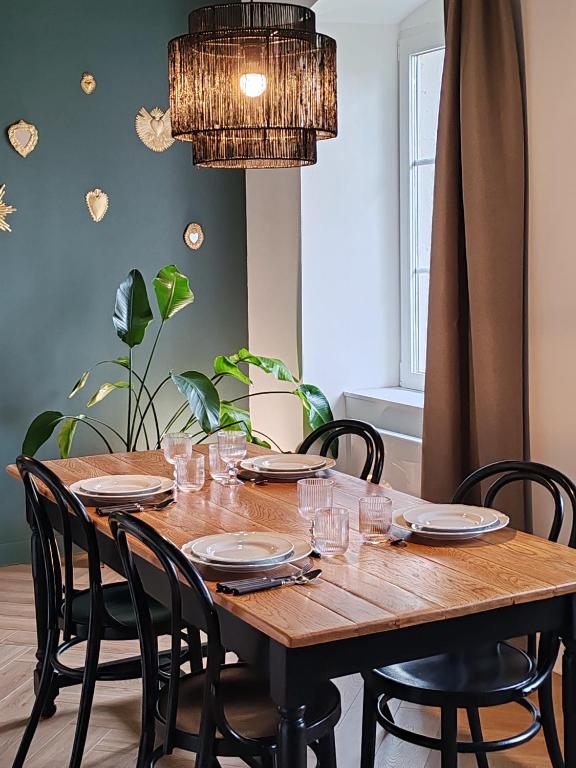 a dining room table with chairs and a chandelier at L'Oiseau vert - calme, ressourçant et proche du centre ville in Montbéliard
