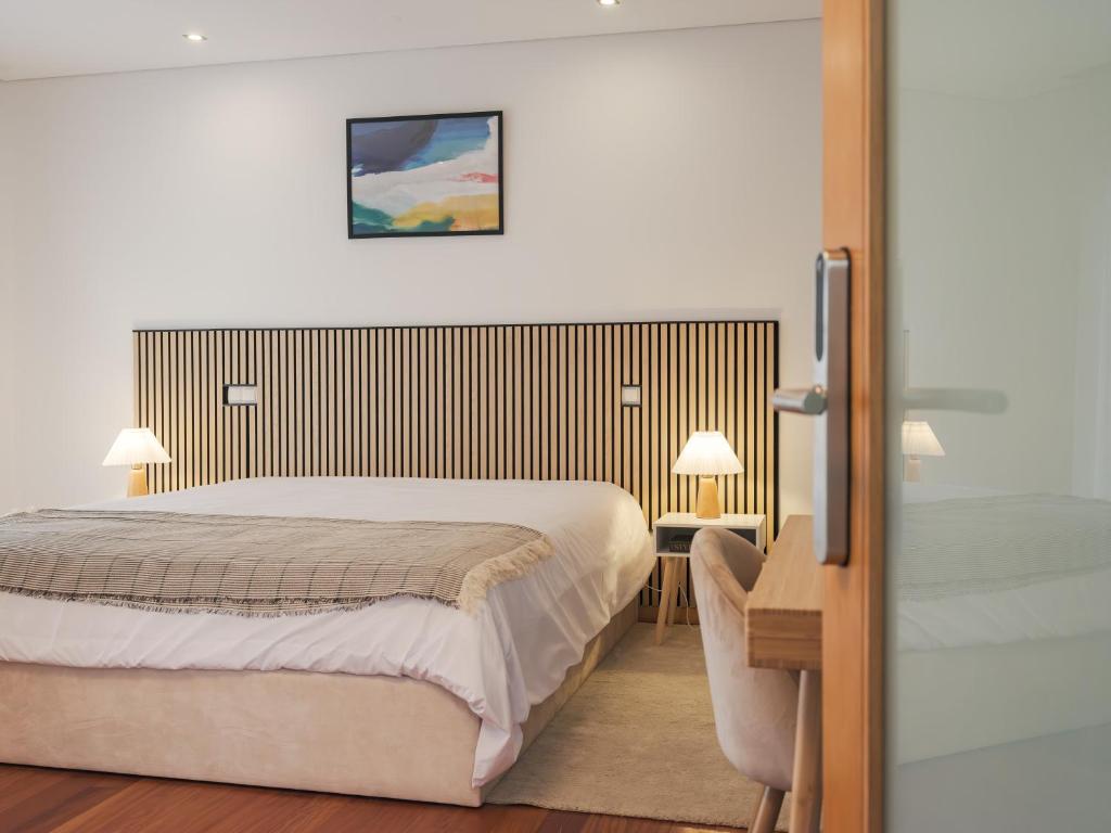 a hotel room with a bed and a desk and a bed sidx sidx at Dom Carlos Villa in Vila Nova de Gaia