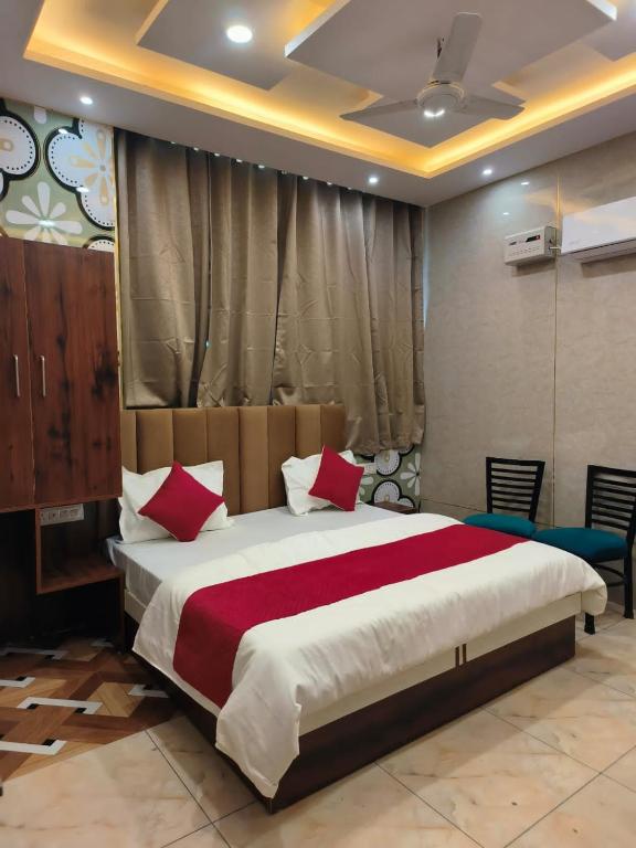 a bedroom with a large bed with red pillows at Punjabeez Restaurant in Patiāla