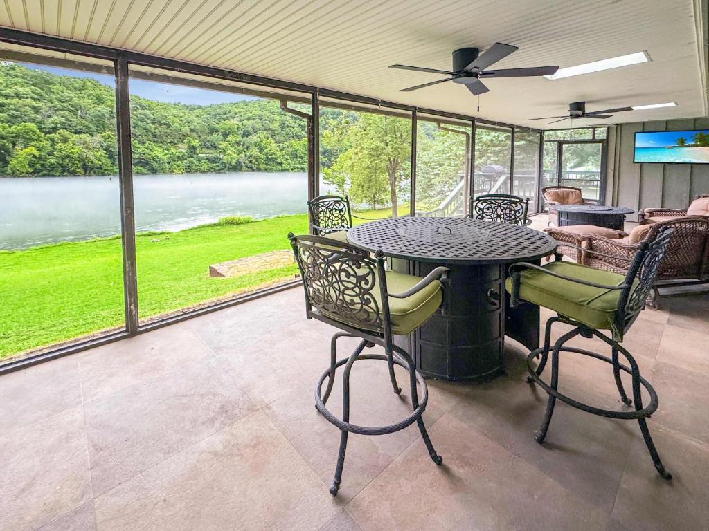 a dining room with a table and chairs and a large window at Riverfront Retreat - Right next to the White River in Norfork