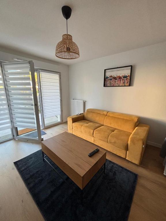 a living room with a couch and a coffee table at Appartement neuf in Linxe