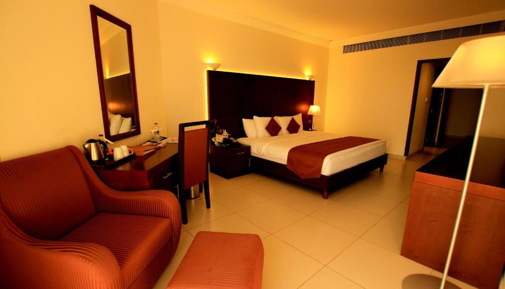 a hotel room with a bed and a chair at Sohar Beach Hotel in Sohar