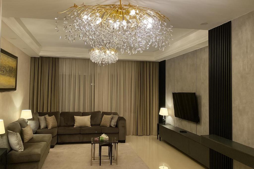 a living room with a couch and a chandelier at haya abdun in Amman