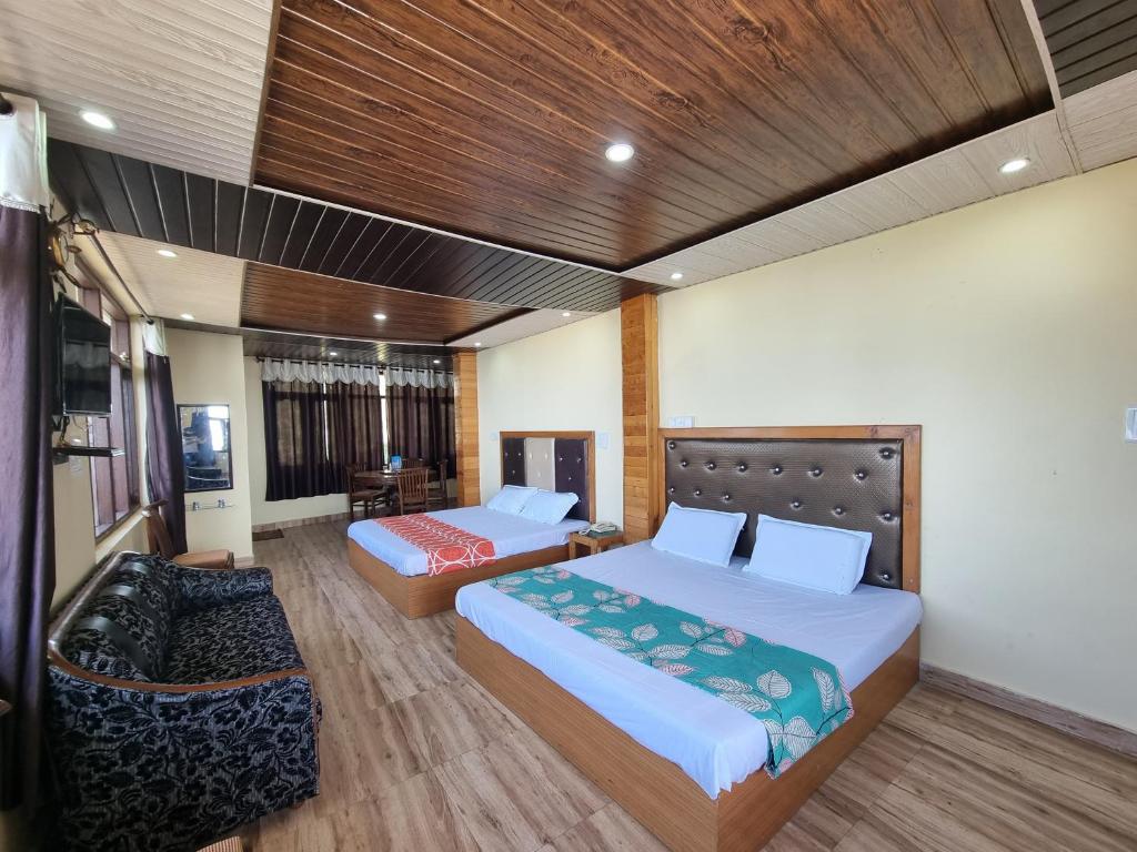 a hotel room with two beds and a couch at Smart Hill Kalatop, Dalhousie in Dalhousie