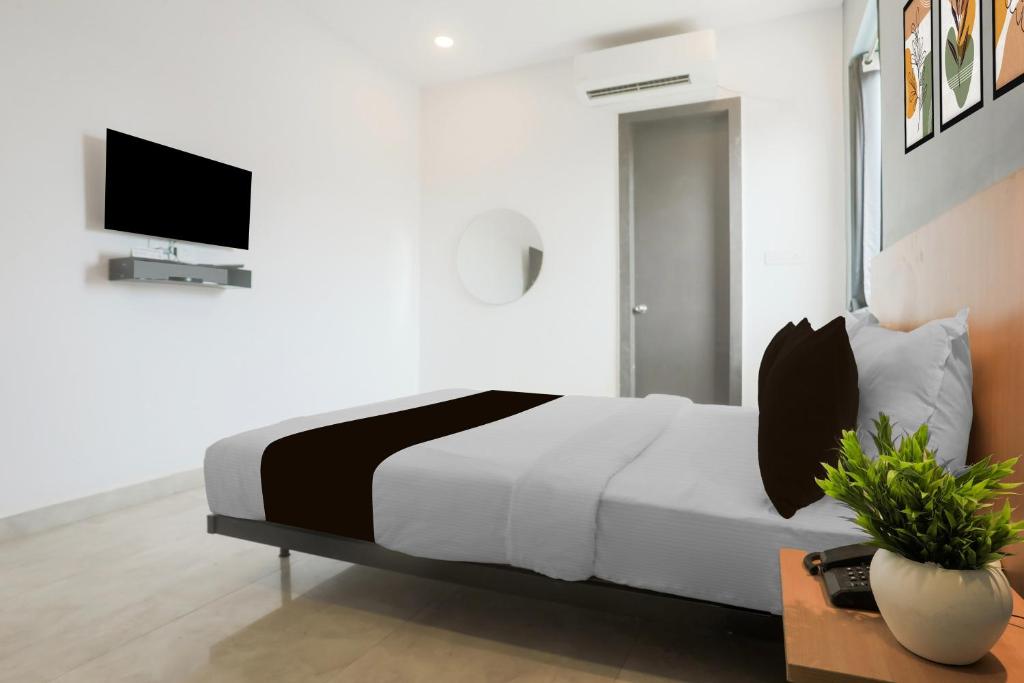 a bedroom with a bed and a tv on a wall at Hotel O Vivek inn Palace in Prayagraj