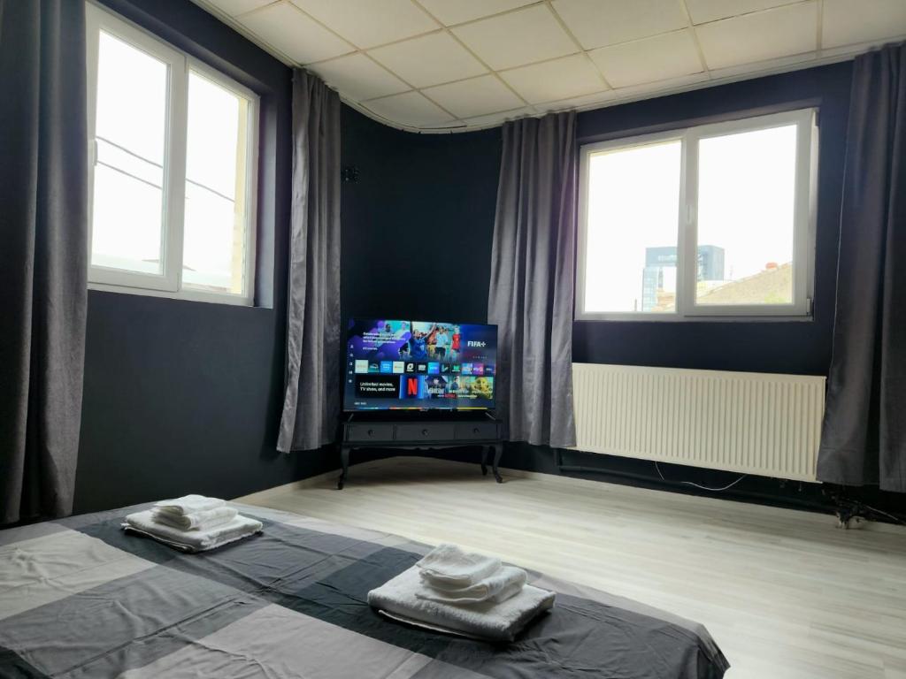 a room with a bed and a tv in it at The Nomads Nest - Old Town in Bucharest