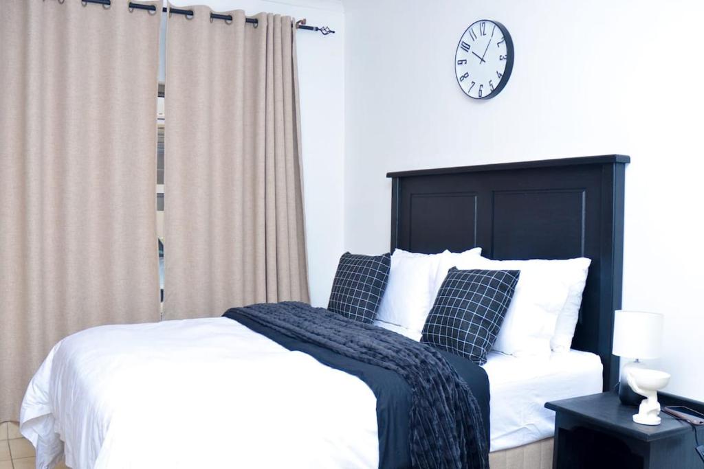 a bedroom with a bed and a clock on the wall at House For Six Adults in Witbank