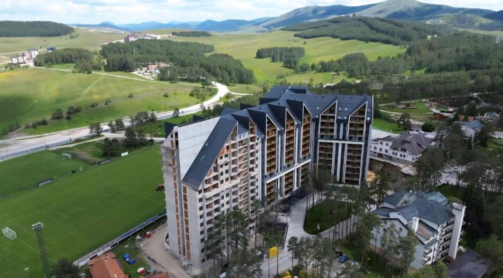 une vue aérienne sur un bâtiment avec des montagnes en arrière-plan dans l'établissement Royal Garden Centar apartmani, à Zlatibor