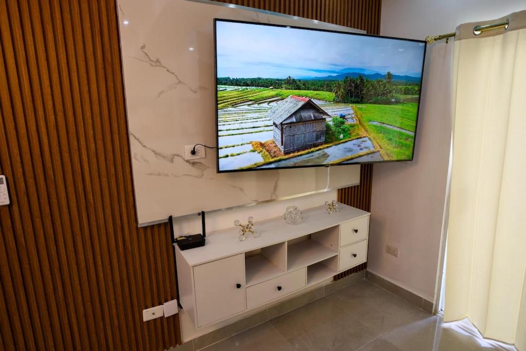 a flat screen tv hanging on a wall in a room at Amazing 2BR apartment near the airport in Los Frailes