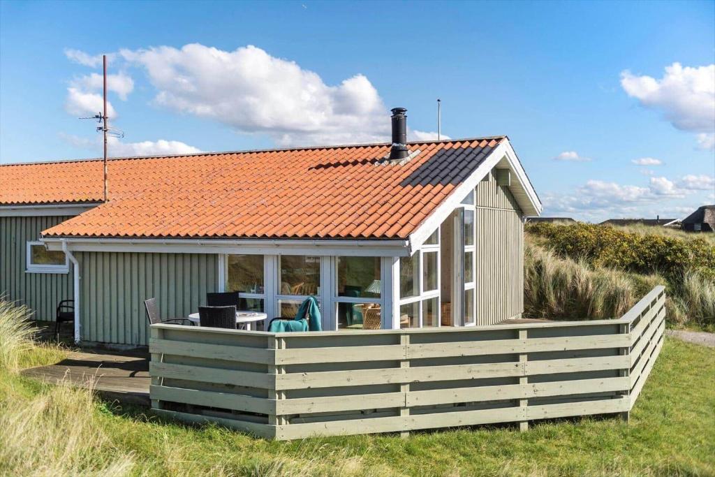 a small house with an orange roof on a deck at FAN076-Fano-Slunden-123 in Fanø