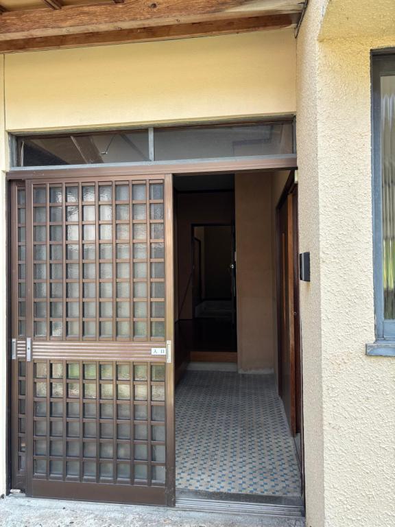 una entrada a un edificio con una puerta de madera en Guesthouse今井邸, en Tonami