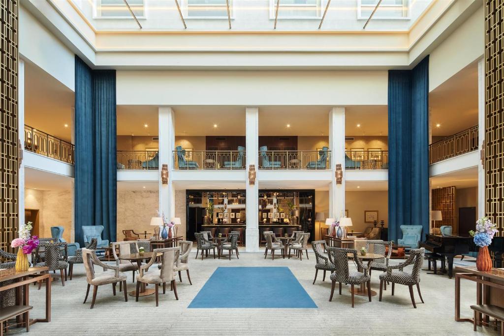 a lobby of a hotel with tables and chairs at Tivoli Avenida Liberdade Lisboa – A Leading Hotel of the World in Lisbon