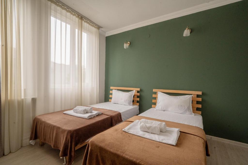 two beds in a room with green walls at Hotel & CoWorking in Tbilisi City
