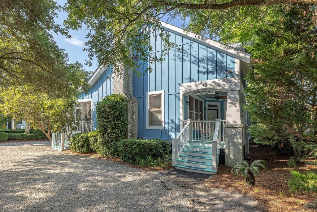 a blue house with stairs leading to the front door at 12 Live Oak Place in Demere Park