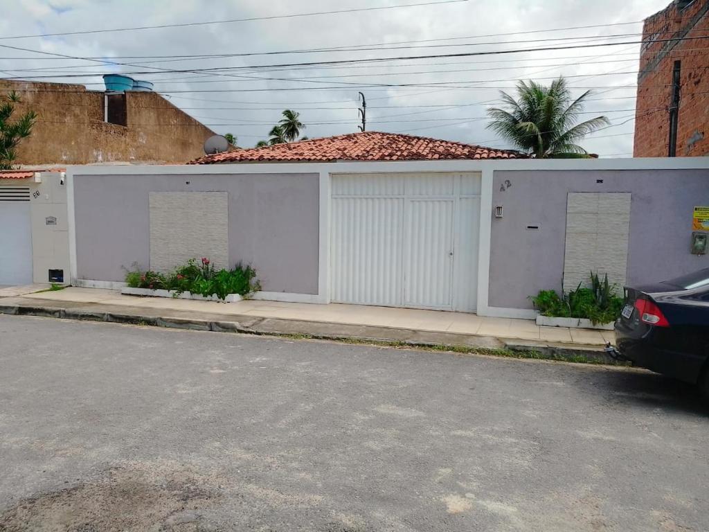 un edificio bianco con due porte garage su una strada di Alojamento Maceió a Maceió