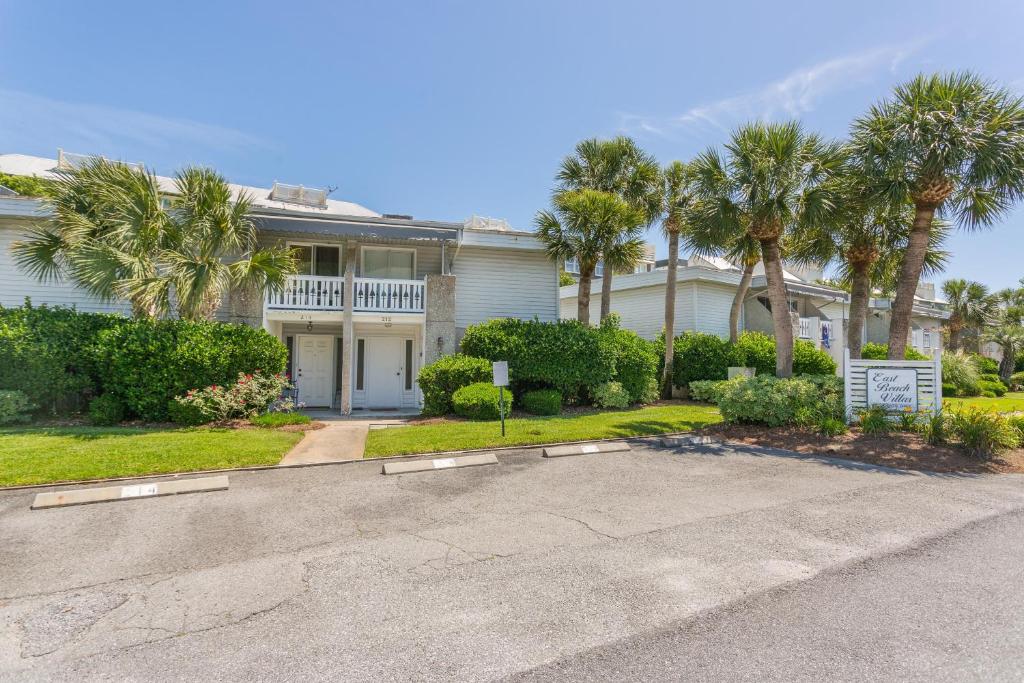 a large white house with palm trees and a driveway at 212 Olive Way in East End