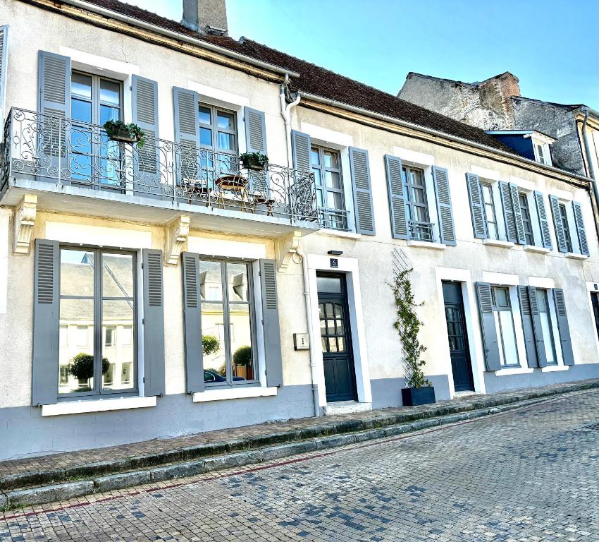 ein weißes Gebäude mit Fenstern und Balkonen auf einer Straße in der Unterkunft Maison Palomase en plein cœur de Sancerre in Sancerre