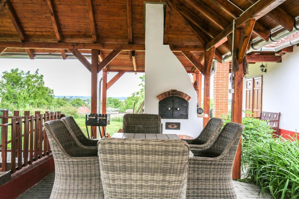 a patio with a table and chairs and a fireplace at Katica Vendégház in Tarcal