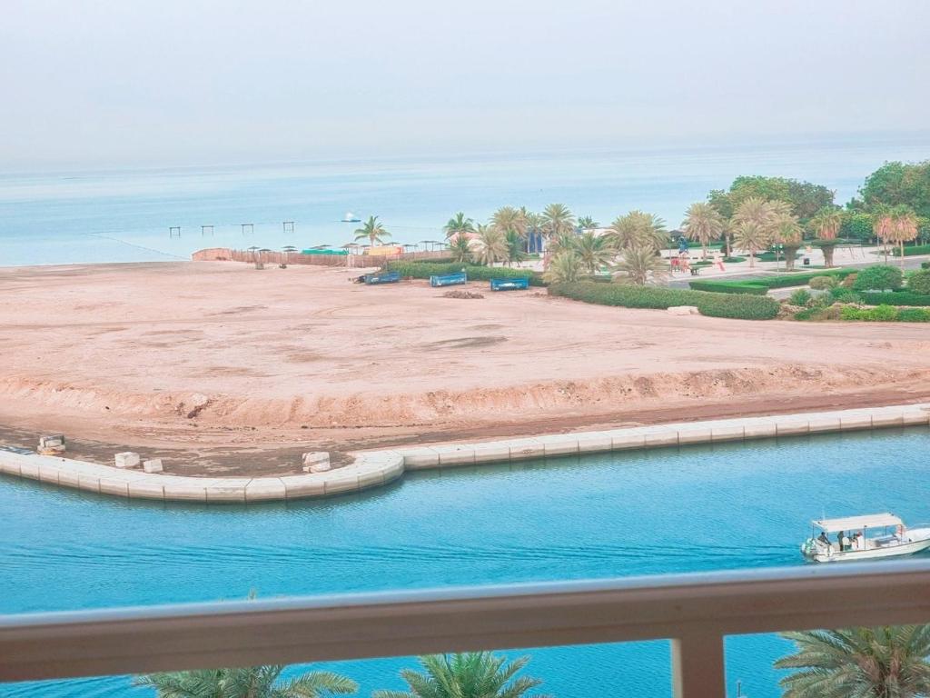 Una vista de la playa desde el balcón de un resort. en شقة منتزة المارينا, en King Abdullah Economic City