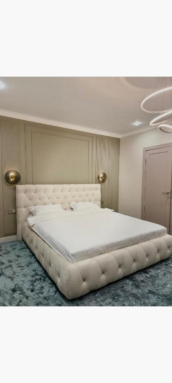 a bedroom with a large white bed in a room at Radamis Hotel in Almaty
