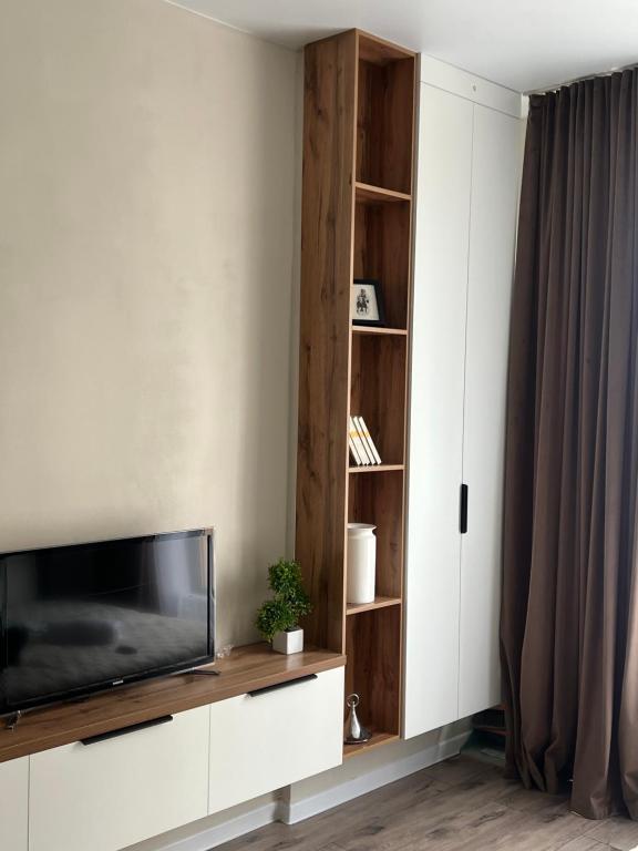 a living room with a flat screen tv on a white cabinet at Уютная студия в жк Four Seasons in Zhezdi