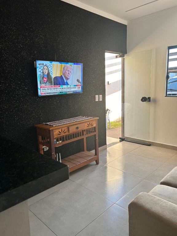 a living room with a flat screen tv on a wall at Linda casa próximo faculdade UCDB mínimo 2 diarias in Campo Grande