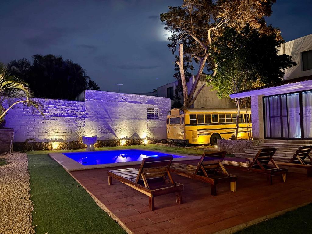 a school bus parked next to a house with a pool at Comodo y brillante alojamiento para 5 in Chuburná de Hidalgo