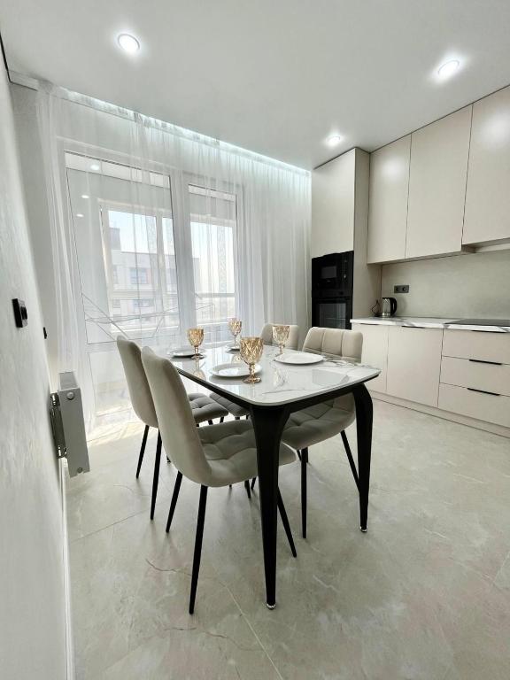 a dining room with a table and chairs in a kitchen at Arena Park apartments in Almaty