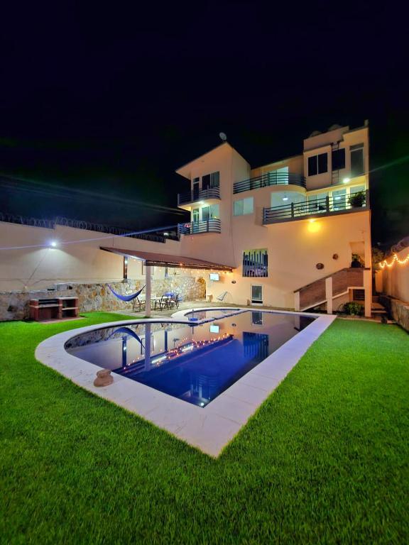 a large house with a swimming pool at night at Preciosa casa para Descanso en Tequesquitengo in Tequesquitengo