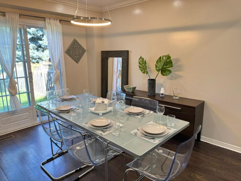 Un comedor con una mesa de cristal y sillas. en Stylish Mississauga Escape Near Downtown, en Mississauga