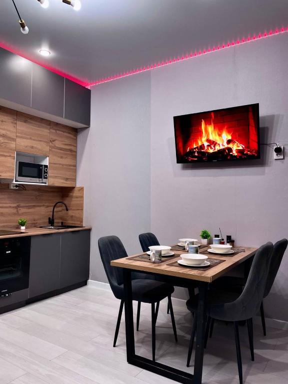 Un comedor con mesa y chimenea. en Квартира посуточно в элитном ЖК, en Zhezdi