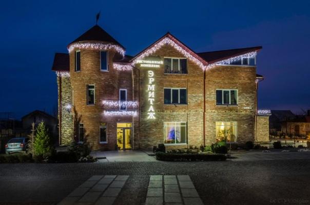a large brick building with lights on it at night at Ermitazh Hotel Complex in Novomoskovsʼk