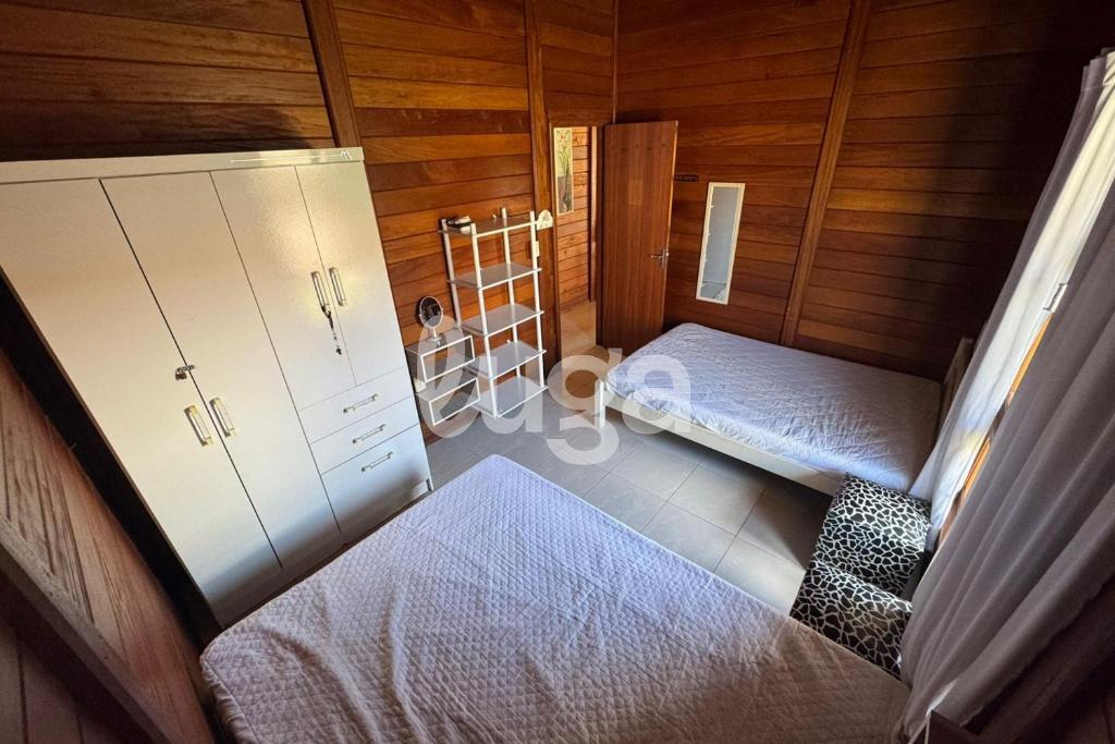 Casa Aconchegante – A 200m da praia da Pinheira في بينيرا: غرفة علوية بسريرين و سلم