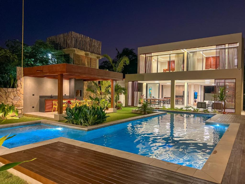 une maison avec piscine la nuit dans l'établissement Vila Libelula, à São Miguel do Gostoso