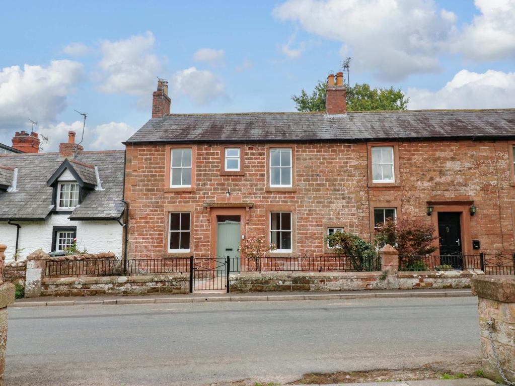 an old brick house on the side of a street at Milford in Great Corby