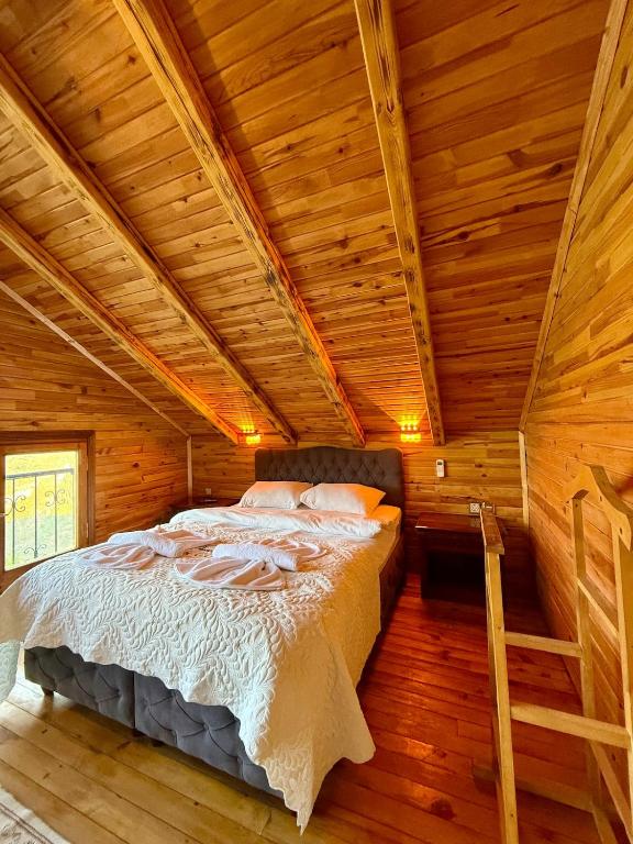 a bed in a room with a wooden ceiling at İsgobya Dağ Evleri 107 in Macka