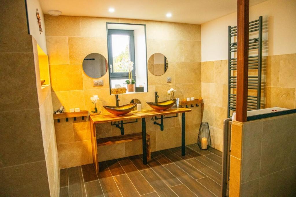 a bathroom with two sinks and a mirror at Charmant Gîte avec sauna au cœur des Hautes Vosges in Ban-sur-Meurthe-Clefcy