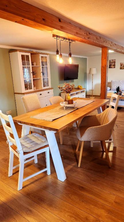 a wooden table and chairs in a room at Landhaus Quatitz in Großdubrau