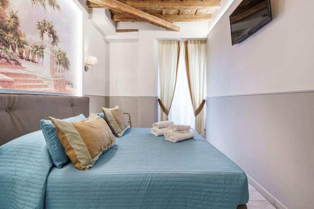 a bedroom with a bed with blue sheets and pillows at Beatrice King Suite Room in Florence
