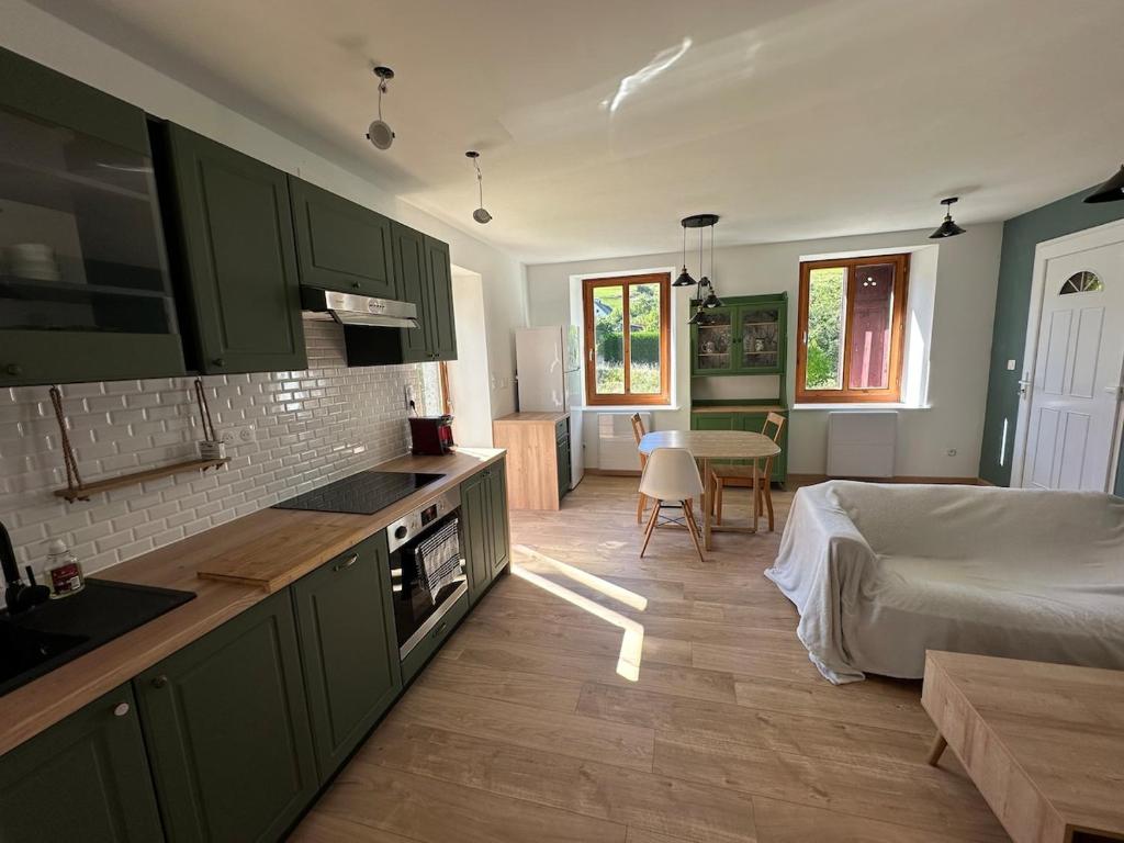 a kitchen with green cabinets and a bed in a room at Appartement 4 personnes in Orbey