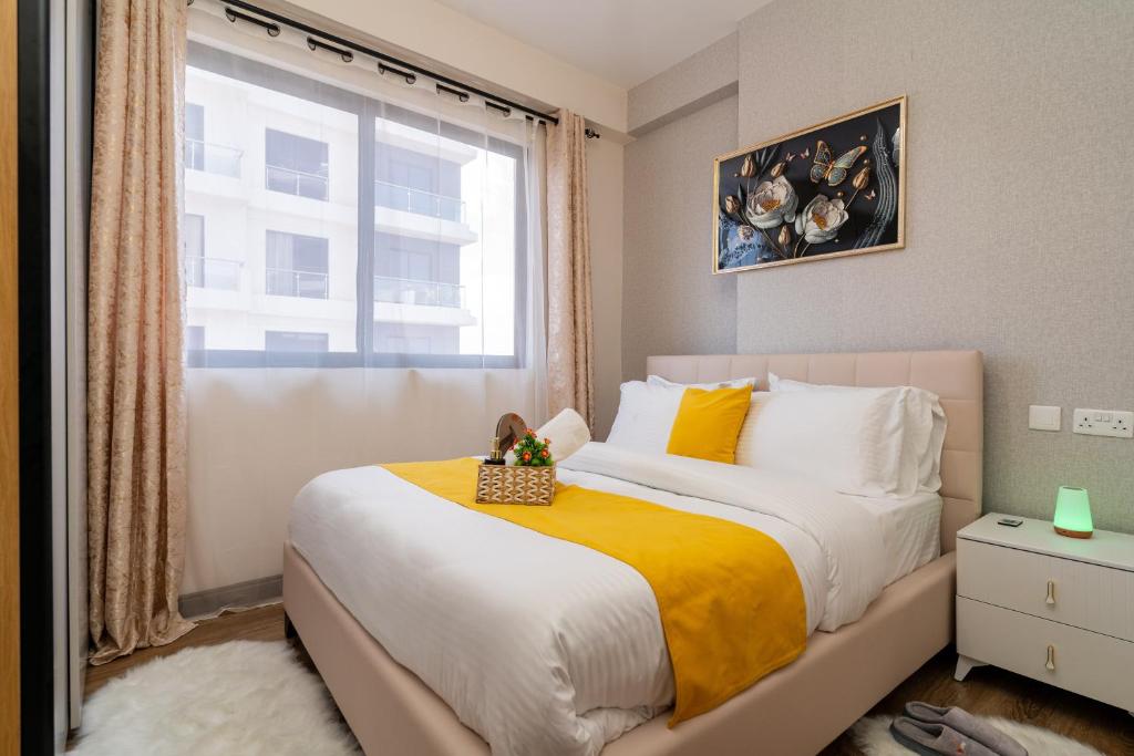 Un dormitorio con una cama grande con ventana. en BMJ sleek homes, en Nairobi