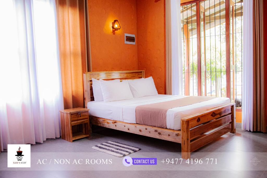 a bedroom with a bed and a large window at Sam's Stay Buduruwagala in Wellawaya