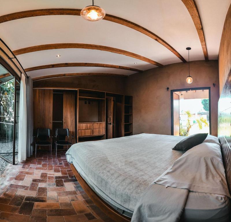 een slaapkamer met een groot bed en een groot raam bij Casa Evelia in Tepoztlán