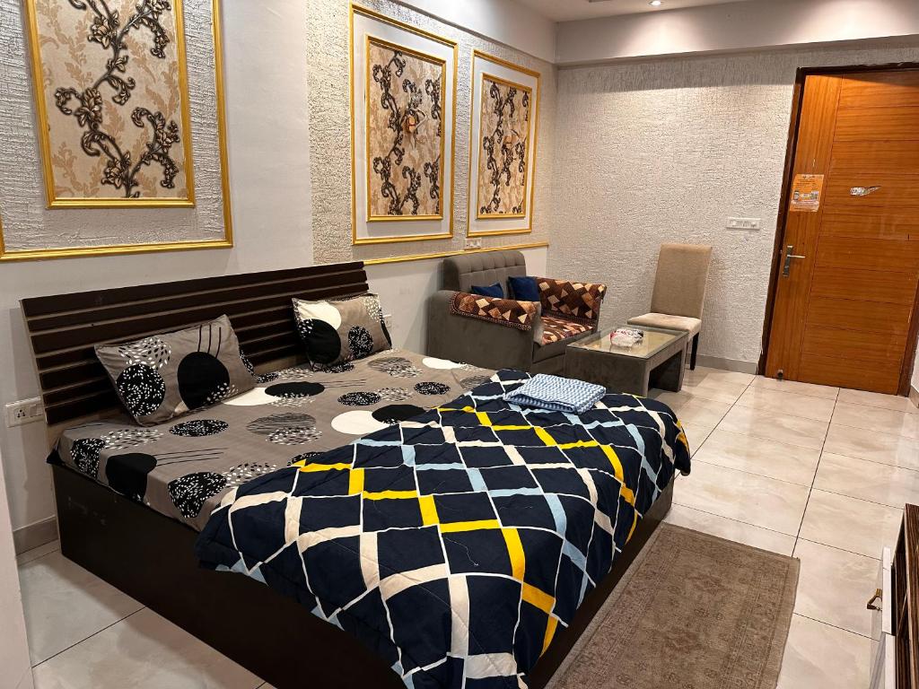 um quarto com uma cama preta e branca e uma cadeira em Bell Rooms em Noida