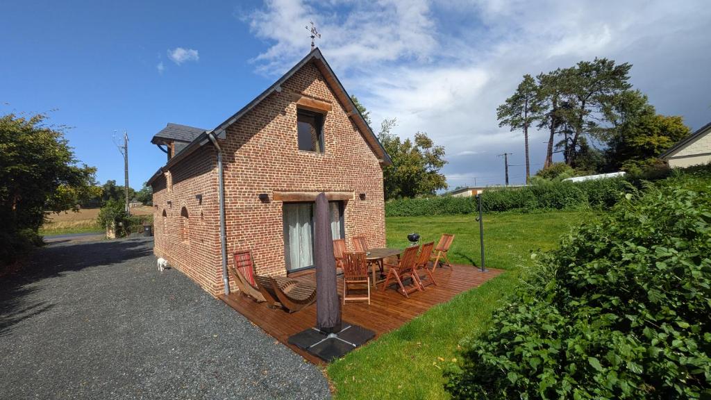 a small brick house with a table and chairs at Le nid d'hirondelle in Sainneville-sur-Seine